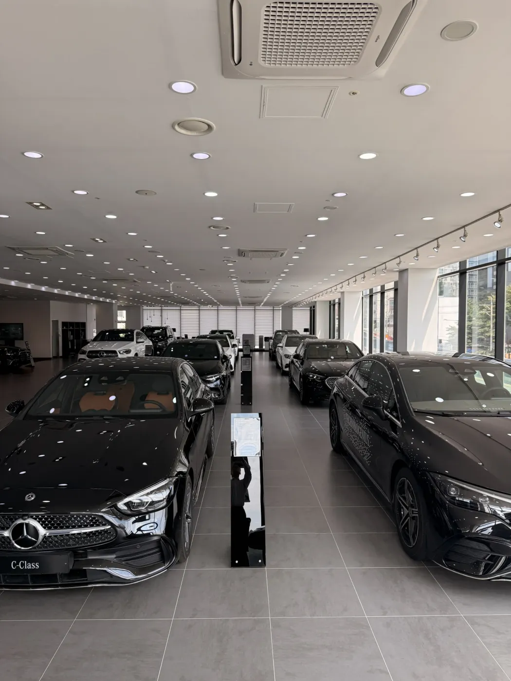 전시장에 여러 대의 Mercedes-Benz 차량이 나란히 전시된 모습